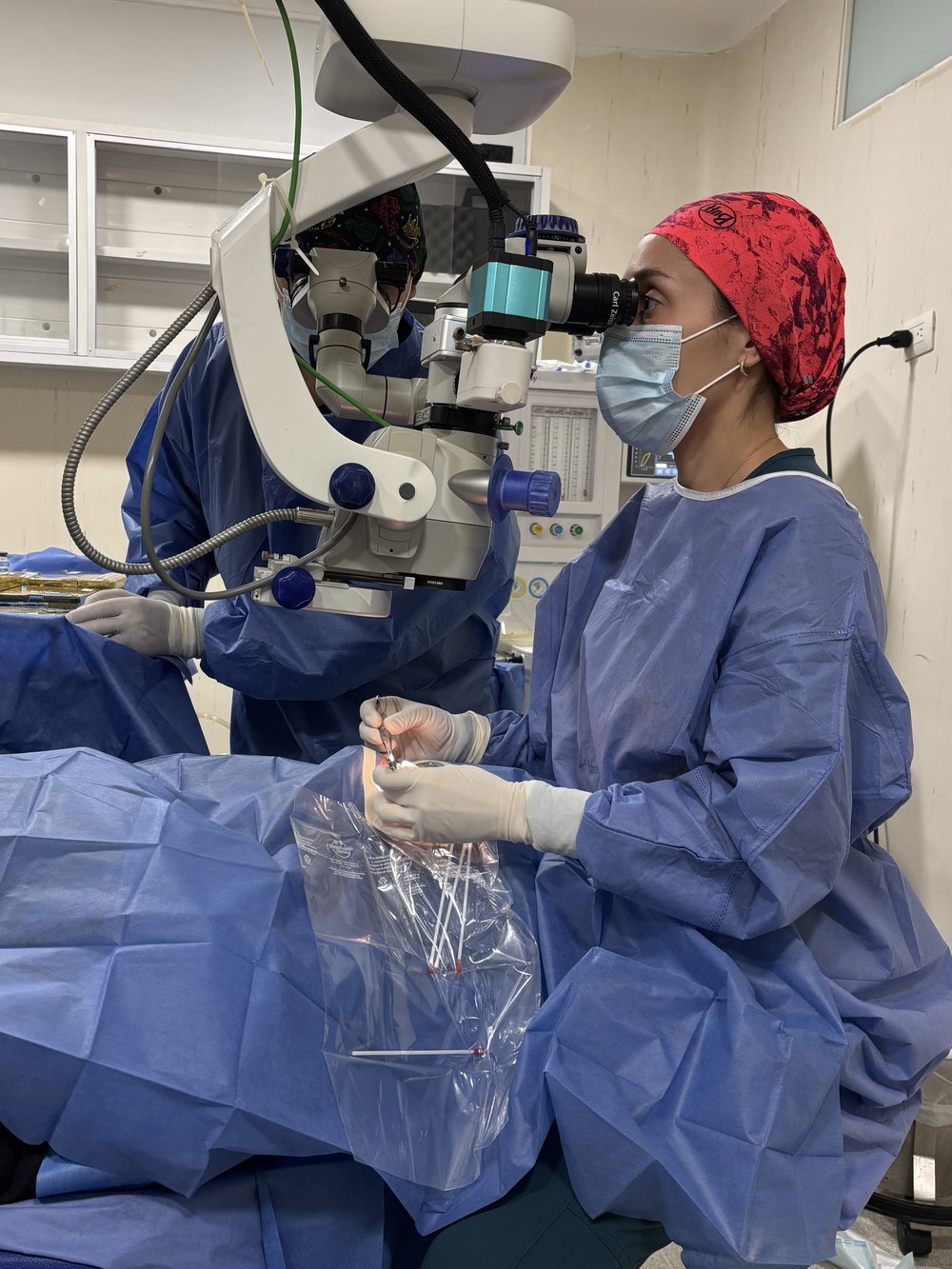 La Dra. Kristell Cantón operando con microscopio quirúrgico